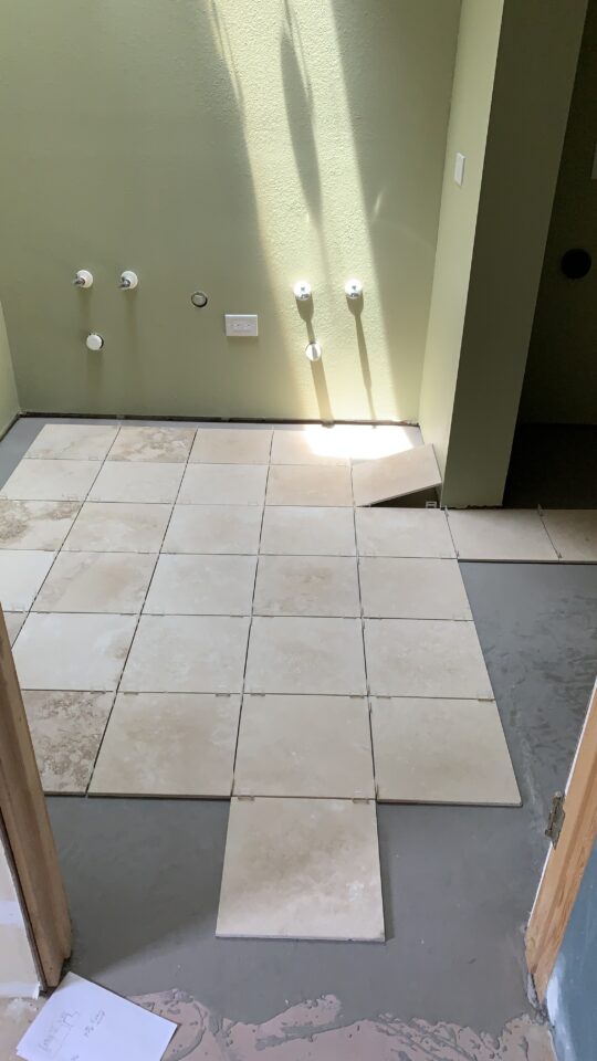 Tiles laid out on the bathroom floor.